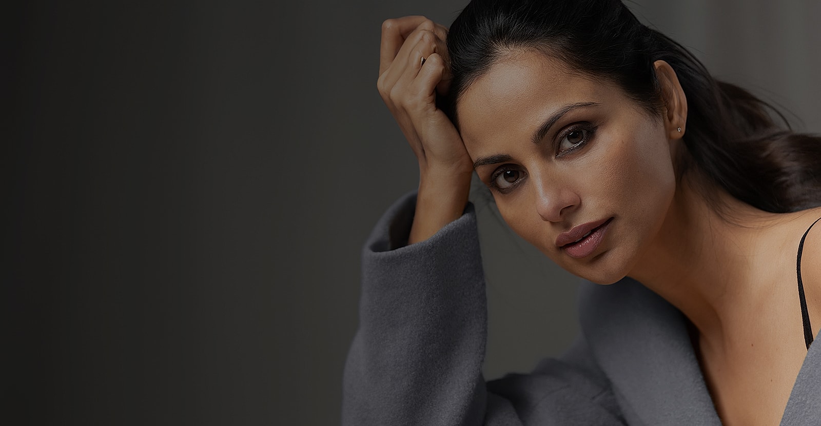 Smiling woman in a dimly lit room.