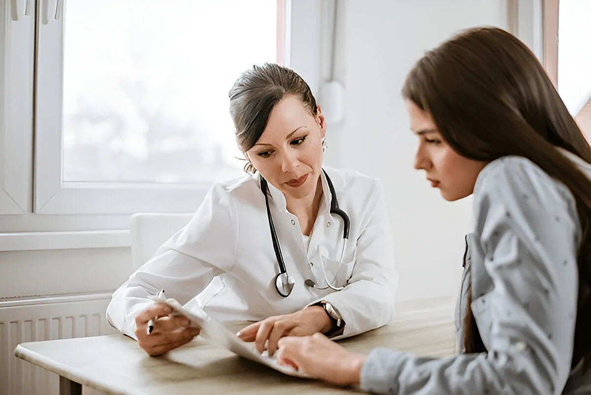 Doctor consulting with patient at a table.