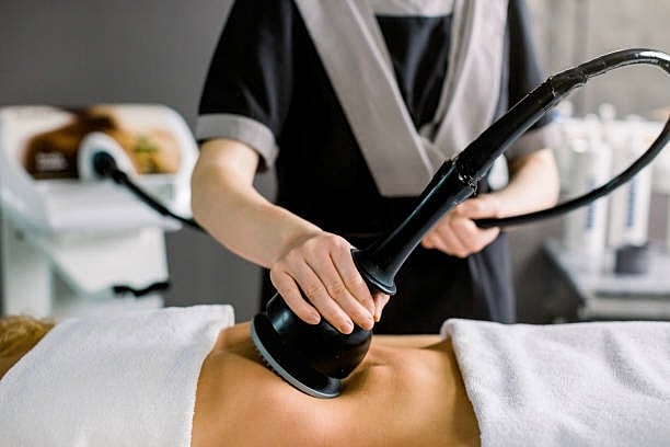 Body treatment with ultrasound device on back.