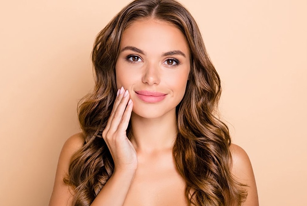 Woman with long hair smiling softly at camera
