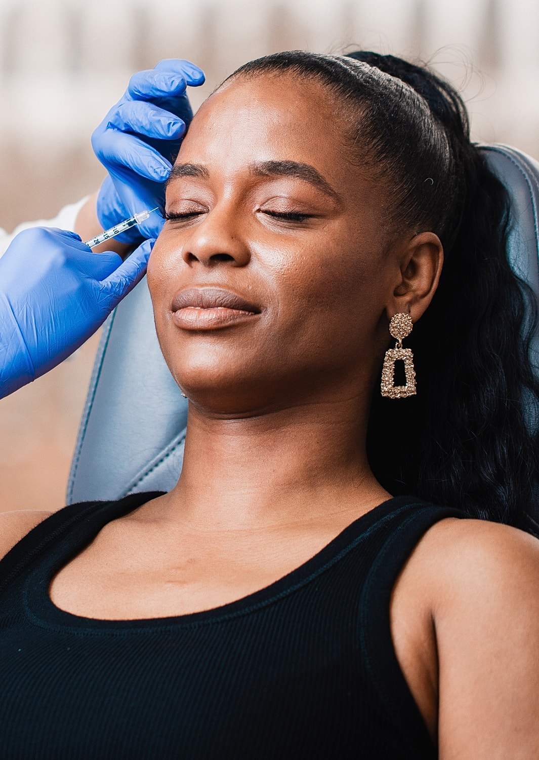 Woman receiving cosmetic treatment with syringe.