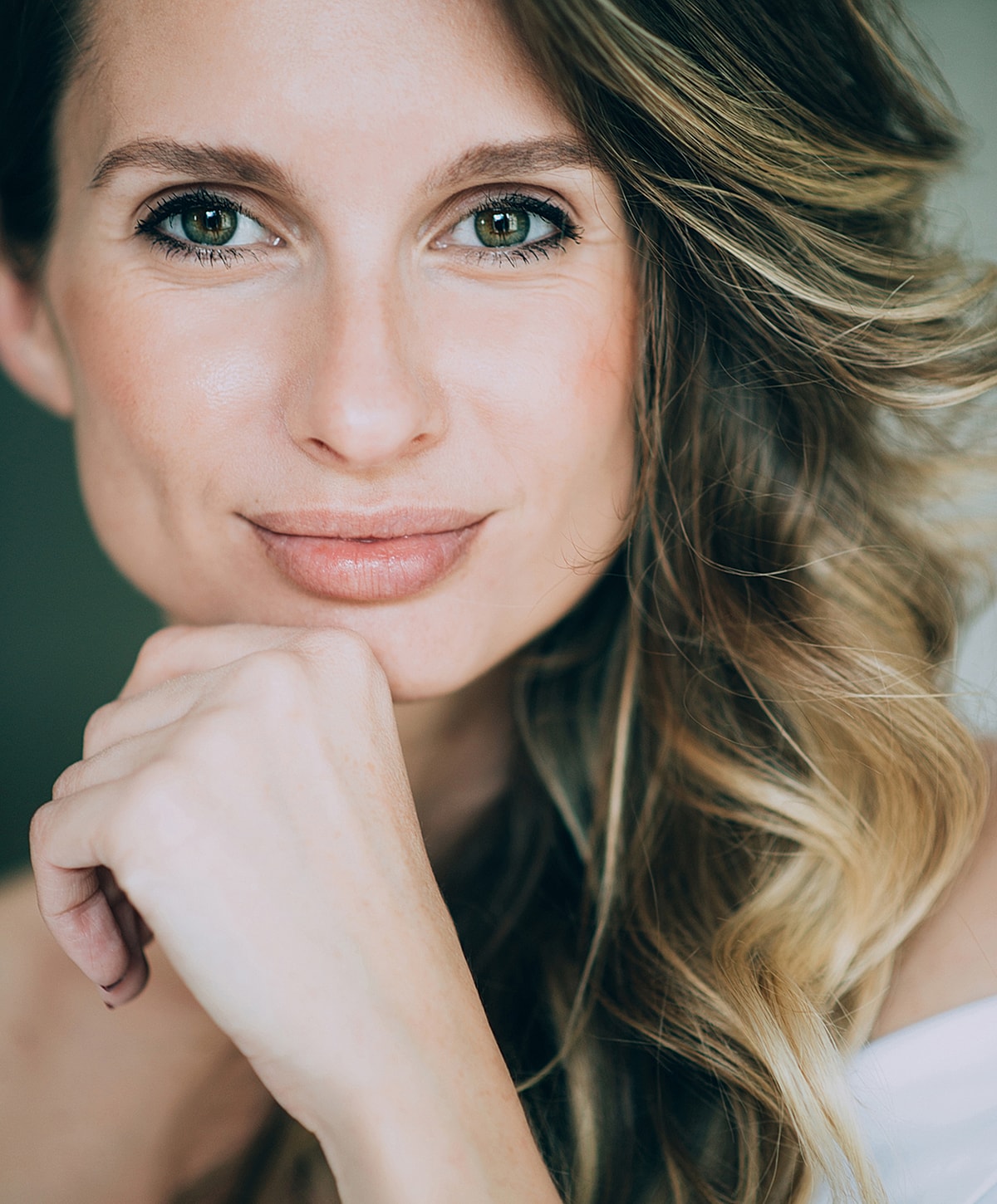 Close-up of a thoughtful woman with wavy hair.