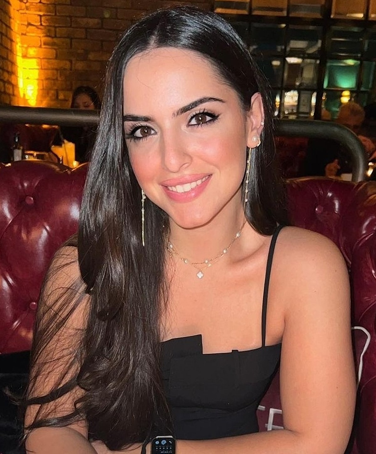 Smiling woman in a restaurant with long hair.