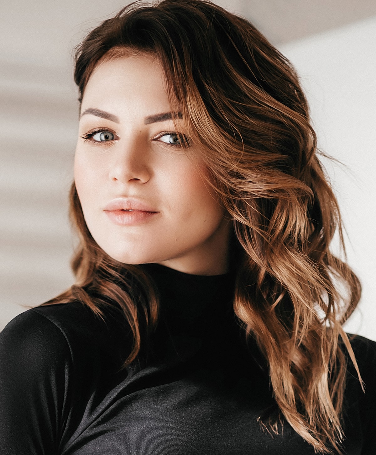 Woman with wavy hair in a black top.
