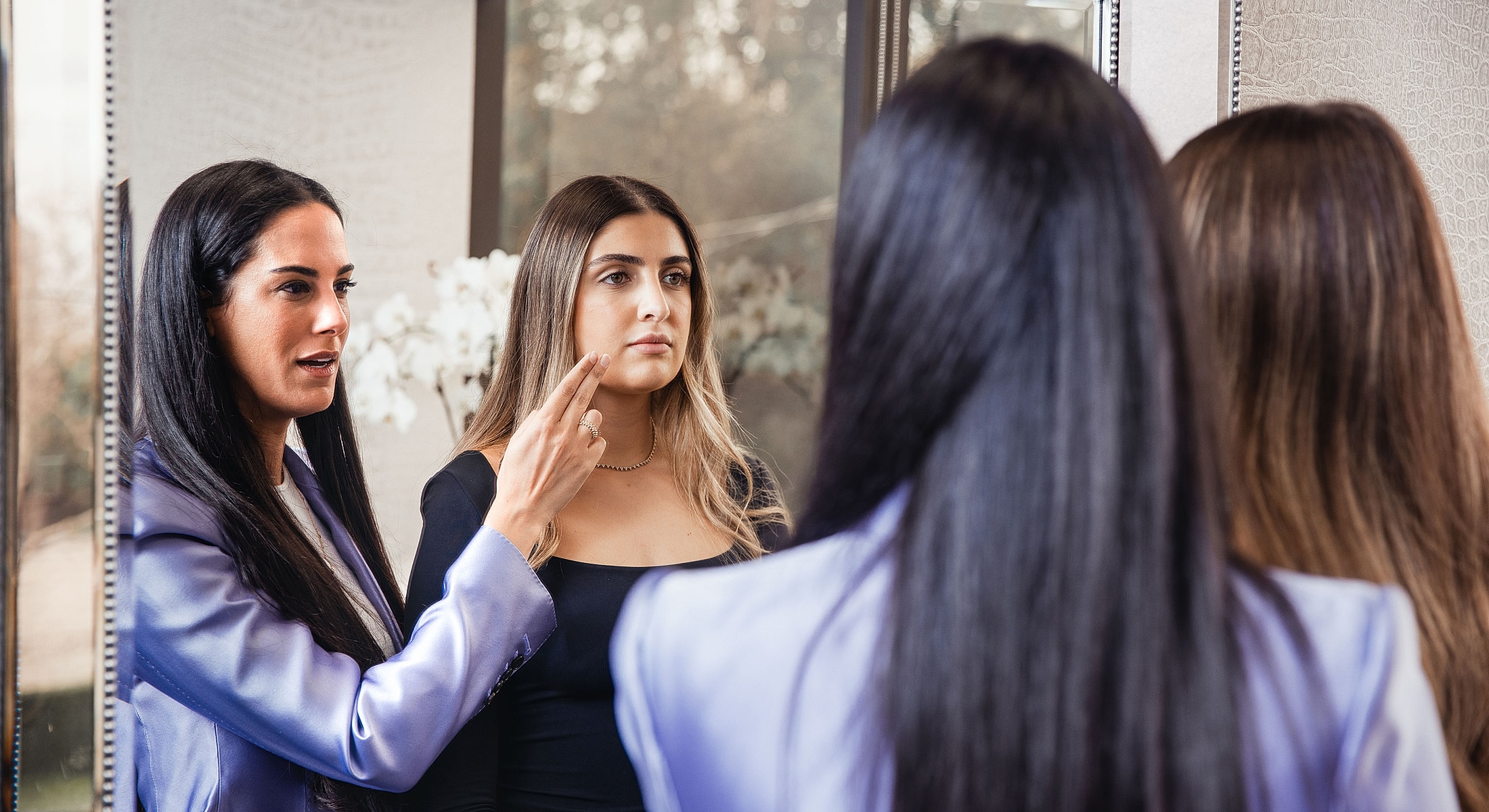 Consultation between two women in front of a mirror.