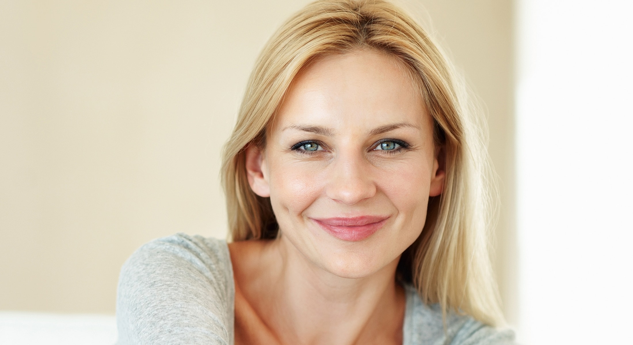 Smiling woman with blonde hair in casual attire.