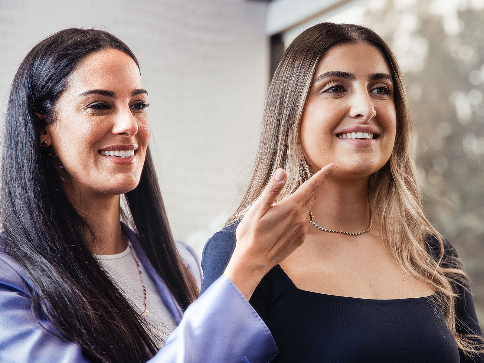 Two smiling women engaged in conversation indoors.