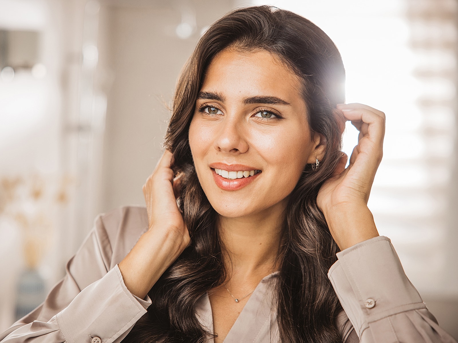 Smiling woman touching her hair indoors.